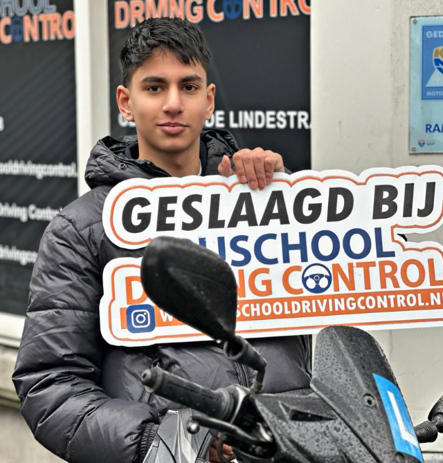 Geslaagde scooterleerling Dennis met helm en Geslaagd-bord voor kantoor Rijschool Driving Control Rotterdam