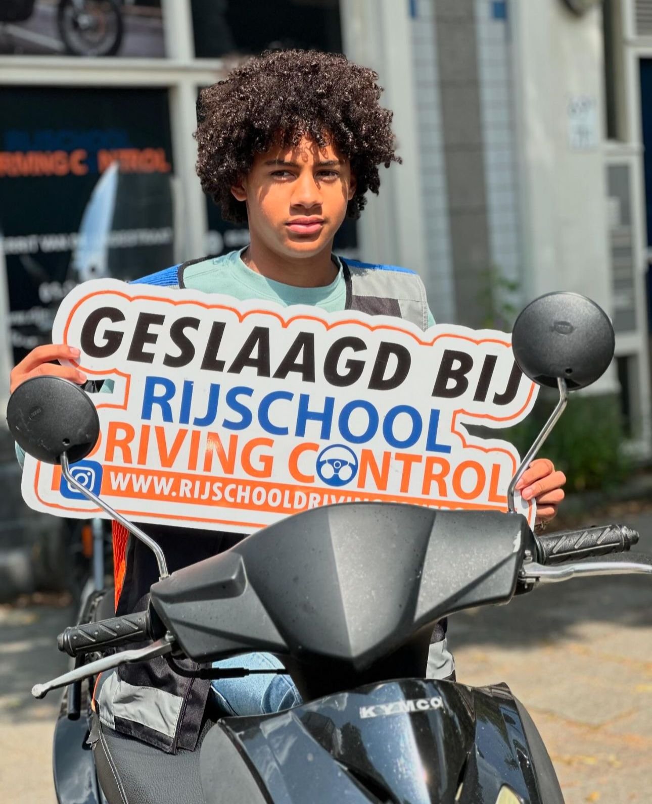 Geslaagde scooterleerling Sven op scooter met Geslaagd-bord Rijschool Driving Control Rotterdam